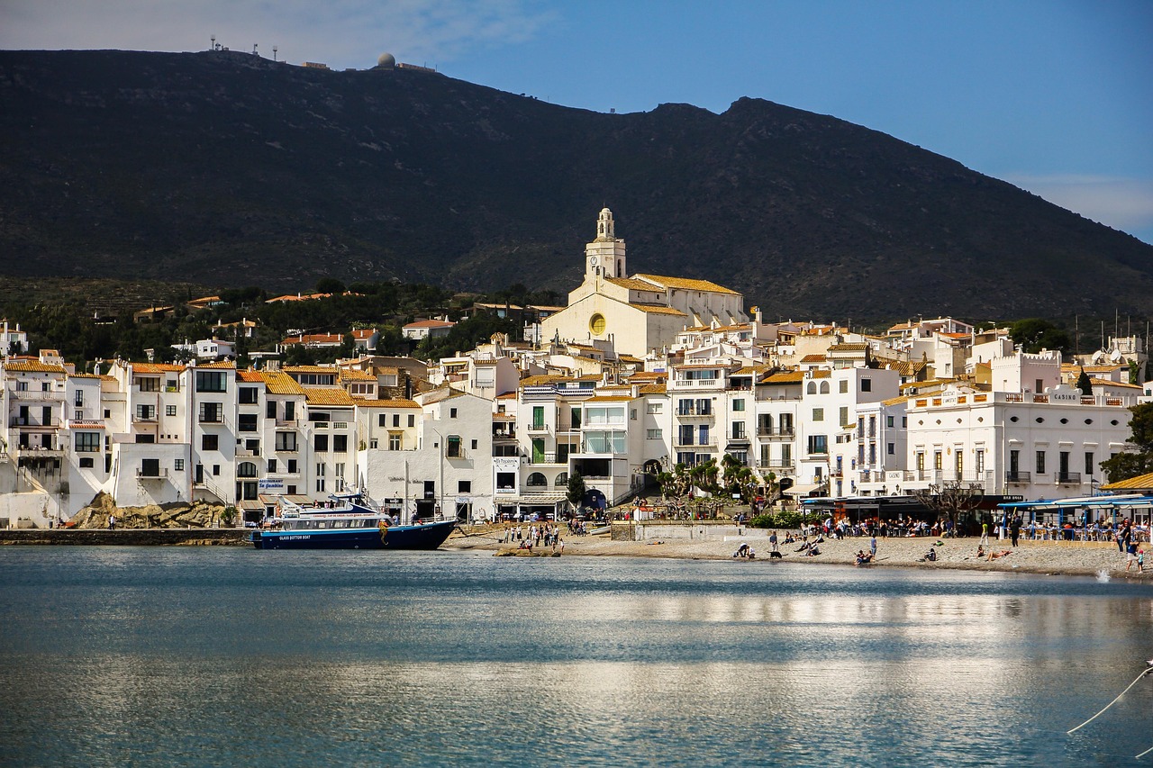 Town beaches in Cadaques with boats and pebbles